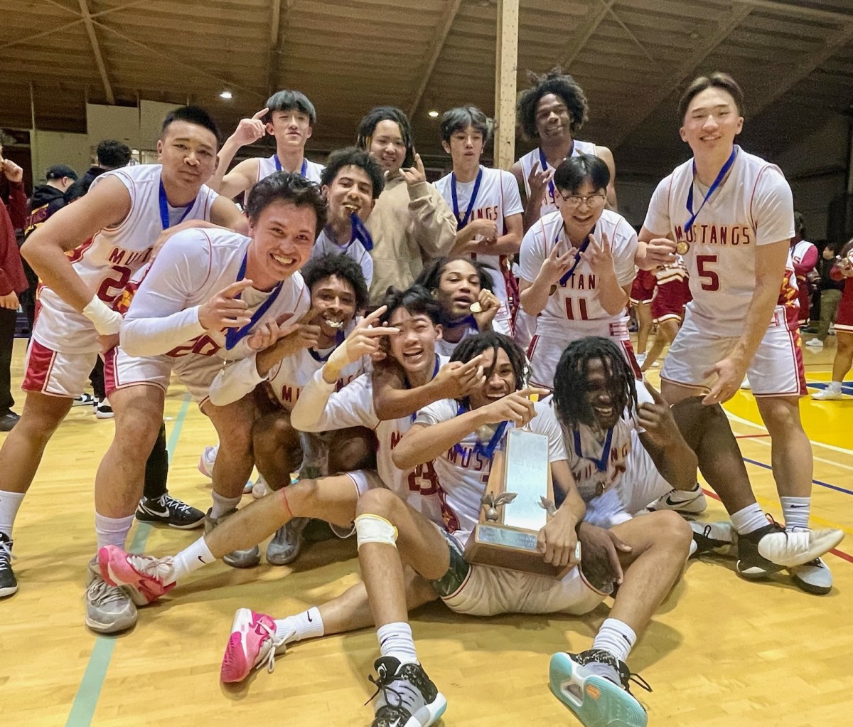 Lincoln's boys celebrating a third straight and 14th San Francisco Section title Friday at Kezar Pavilion